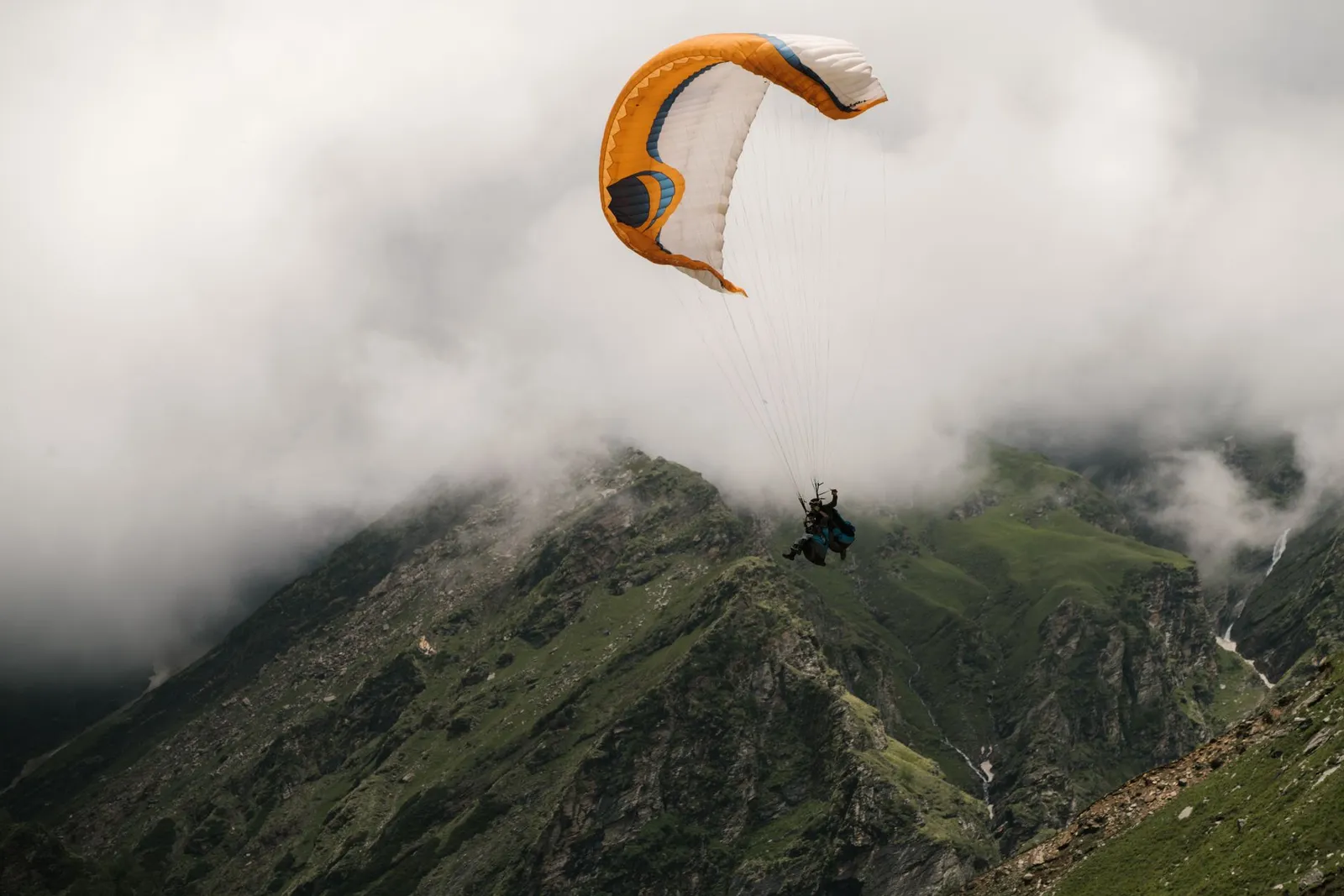 Paragliding over green meadow
