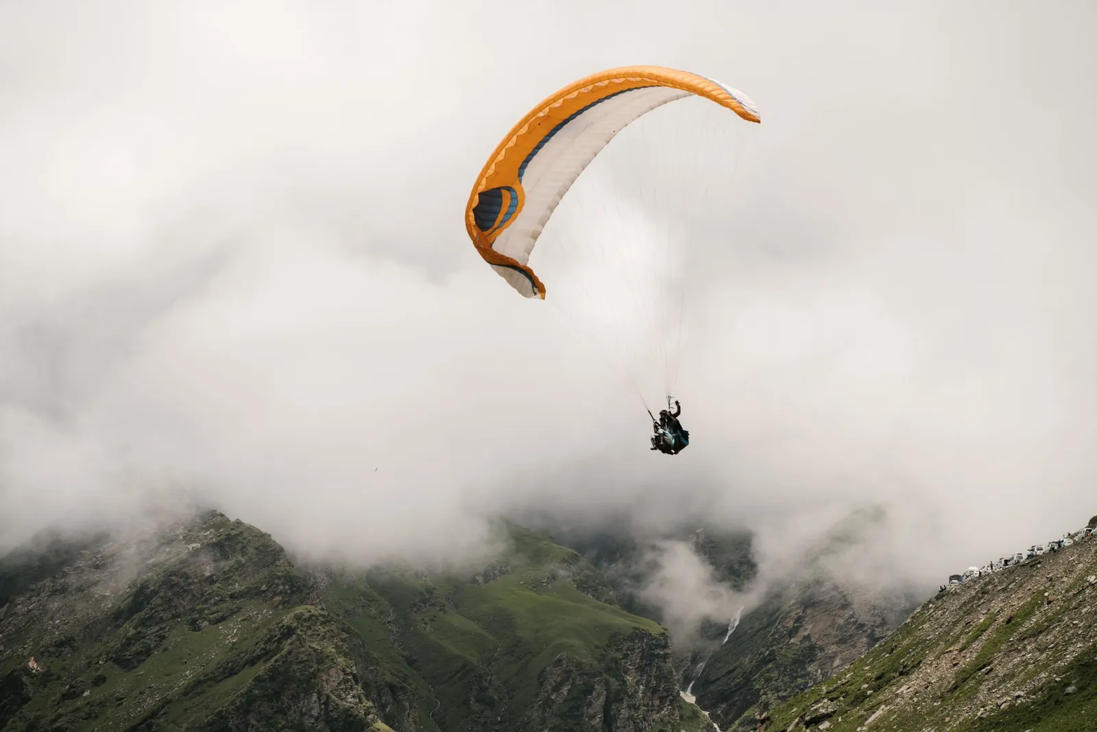 Paragliding over green meadow