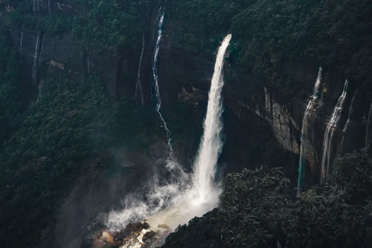 The multiple parallel streams of the Seven Sisters Falls dropping over a dark cliff face near Cherrapunji